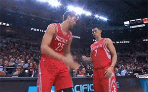 Two Basketball Players Wearing Red Jerseys With Rockets On Them Shake Hands GIF