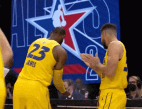 two basketball players wearing yellow uniforms with the number 23 on the back