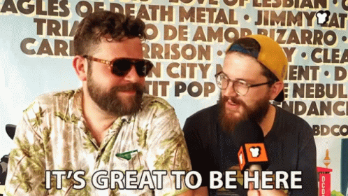Two Bearded Men in Front of Sign It's Great to Be Here
