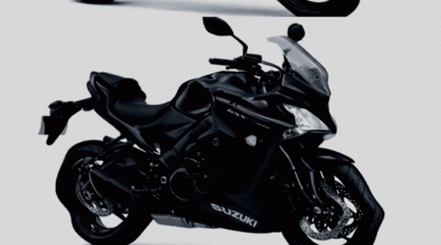 Two Black Suzuki Motorcycles Side By Side On A Gray Background GIF