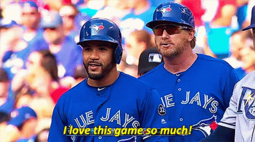 Two Blue Jays Baseball Players Are Standing Next To Each Other In The Dugout . GIF