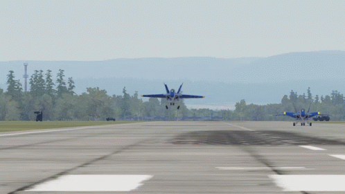 Two Blue Jets Are Taking Off From A Runway With Trees In The Background GIF