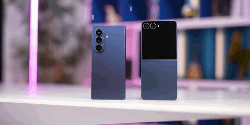 Two Blue Phones Are Sitting On A Table With A Pink Light In The Background GIF