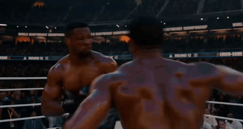 two boxers are fighting in a ring with a sign that says world heavyweight championship in the background