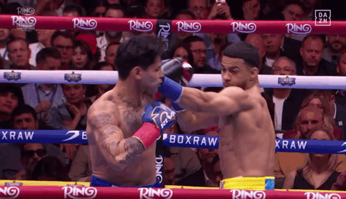 Two Boxers Fighting in Ring With Ring on Ropes