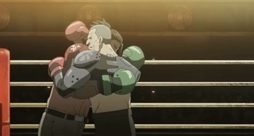 Two Boxers Hugging In A Boxing Ring With One Wearing A Glove That Says ' Pa ' On It GIF