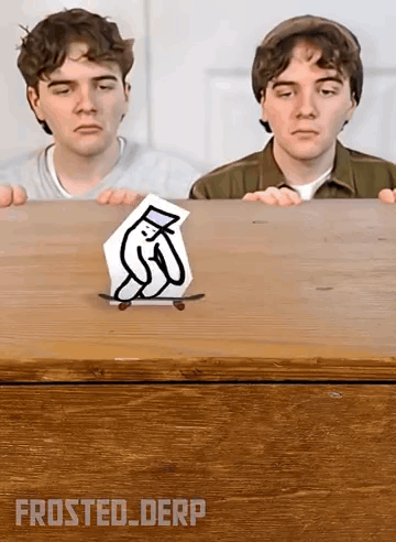 Two Boys Are Looking At A Drawing Of A Penguin On A Skateboard On A Wooden Table . GIF