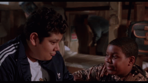 Two Boys Are Sitting Next To Each Other With The Words This Pleases Me Behind Them GIF