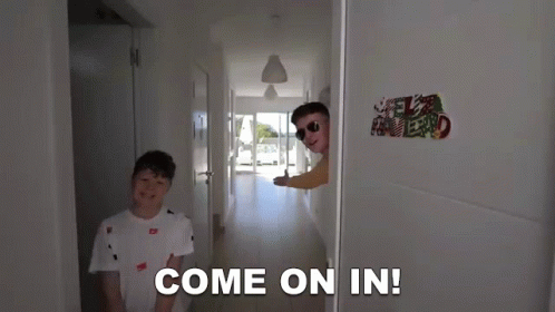 Two Boys Are Standing In A Hallway And One Of Them Says Come On In GIF