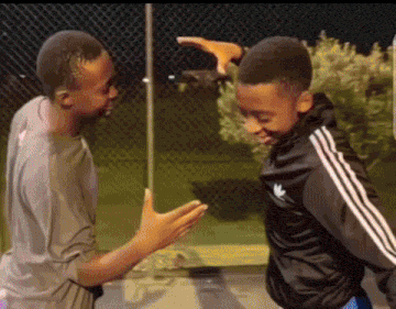 Two Boys Are Standing Next To Each Other And One Of Them Is Wearing A Black Adidas Jacket GIF