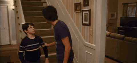 Two Boys Are Standing On A Set Of Stairs And One Of Them Is Wearing A Striped Shirt GIF