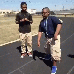 Two Boys Are Standing On A Track And One Of Them Has A Lanyard Around His Neck GIF