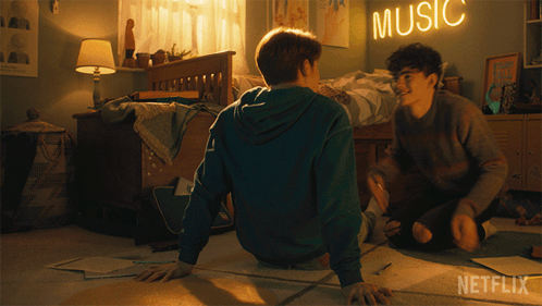 Two Boys Sit On The Floor In A Bedroom With A Music Sign Above Them GIF