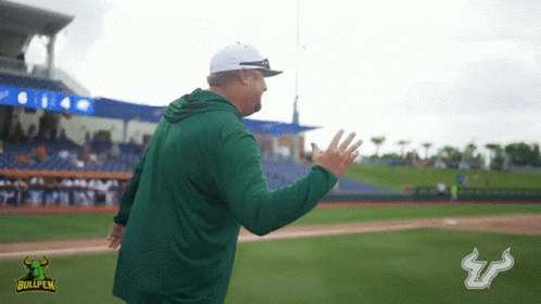 Two Bullpen Football Players Shake Hands in Front of Raymond James Stadium Billboard