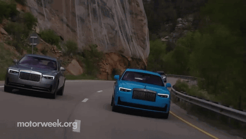 Two Cars Are Driving Down A Road With Motorweek.org In The Corner GIF