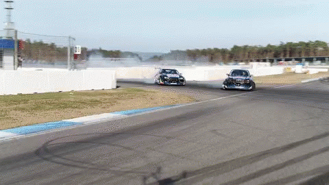 Two Cars Are Racing On A Race Track And One Of Them Has A Sticker On The Side That Says ' Toyota ' GIF