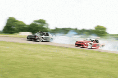 Two Cars Are Racing On A Track And One Is Red GIF