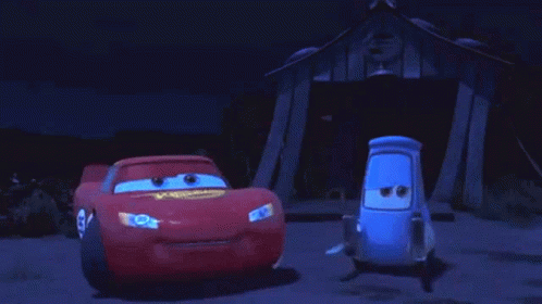 Two Cars Are Standing Next To Each Other In Front Of A Building At Night . GIF