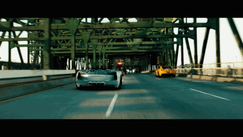 Two Cars Driving on Highway Under Bridge With Ambulance Sign