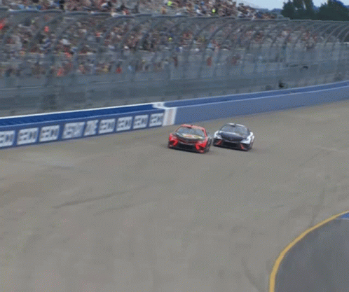Two Cars Racing on Track with Coca Cola Sign