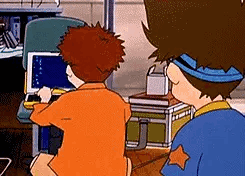 Two Cartoon Characters Are Sitting At A Table Looking At A Laptop Computer . GIF