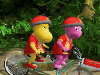 Two Cartoon Characters Riding Tandem Bicycle
