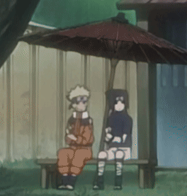 Two Cartoon Characters Sit Under An Umbrella In Front Of A Building GIF