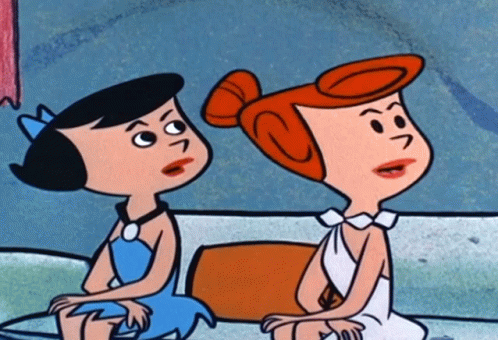 Two Cartoon Characters Sitting Next To Each Other With One Having A S On Her Head GIF