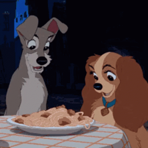 Two Cartoon Dogs Are Sitting At A Table With A Plate Of Spaghetti GIF