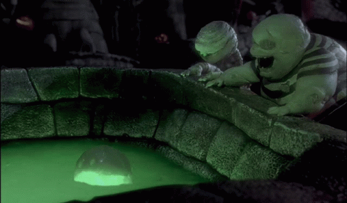 Two Cartoons Look At Glowing Ball In Green Liquid GIF