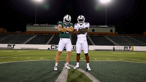 two charlotte football players standing on a field