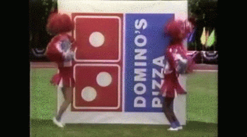 Two Cheerleaders Are Dancing In Front Of A Domino 'S Pizza Logo GIF