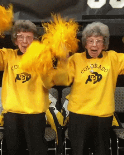 Two Cheerleaders in Yellow Sweaters Saying Colorado