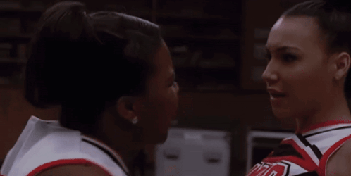 Two Cheerleaders Looking at Each Other, One in UCLA Shirt