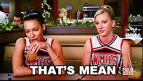 Two Cheerleaders Sitting at Table Saying That's Mean
