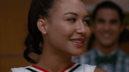 Two Cheerleaders Smiling in Front of Man in Bow Tie