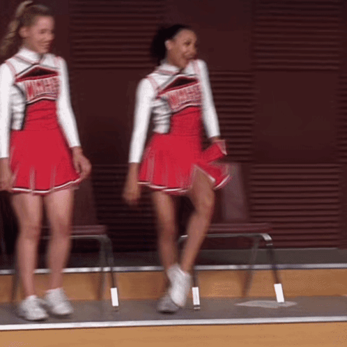 Two Cheerleaders Wearing Red Uniforms That Say Angels On Them GIF