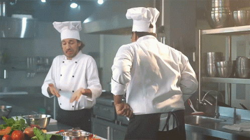 Two Chefs in Kitchen, One in White Hat
