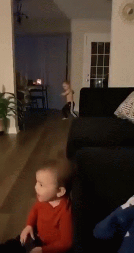 Two Children Playing in Living Room With Couch and Table