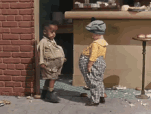 Two Children Standing in Front of Brick Wall