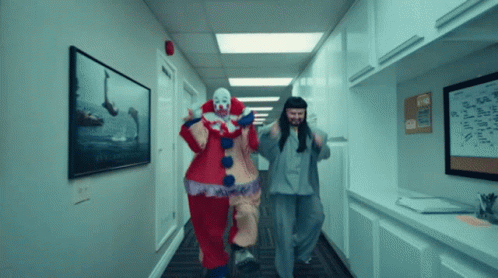 Two Clowns Are Running Down A Hallway With A Sign On The Wall That Says ' A ' GIF