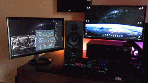 Two Computer Monitors And A Keyboard On A Desk With A Mouse Pad That Says ' Steelseries ' On It GIF