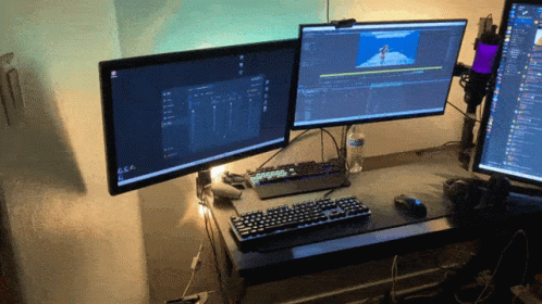 Two Computer Monitors Are Sitting On A Desk With A Keyboard GIF