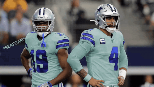 Two Cowboys Players Standing With Seafoam Background GIF