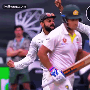 Two Cricket Players Are Playing A Game Of Cricket And One Of Them Is Wearing A Helmet With The Word Cricket On It GIF