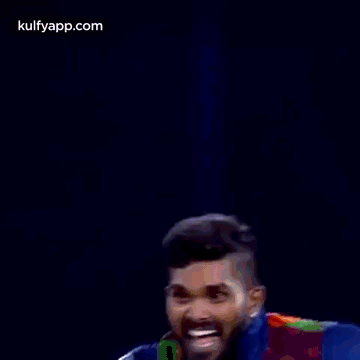two cricket players are standing next to each other and celebrating a victory .