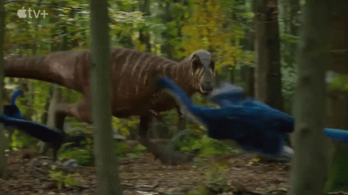 Two Dinosaurs Are Fighting In The Woods With An Apple Tv Logo In The Background . GIF