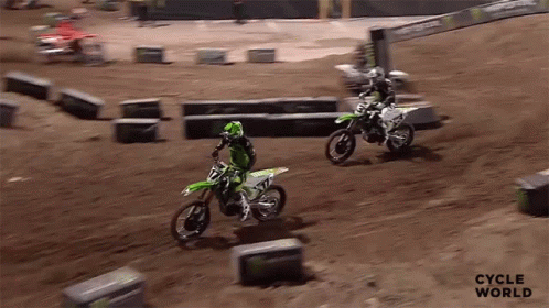 Two Dirt Bike Riders Are Racing On A Dirt Track And The Words Cycle World Are On The Bottom Right GIF
