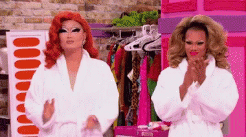 Two Drag Queens in White Robes Standing Together