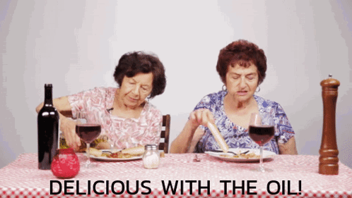 Two Elderly Women Sitting At A Table With The Words " Delicious With The Oil " GIF
